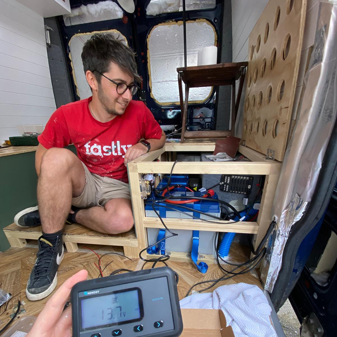 Charlie working on van conversion electrical system inside camper van in 2021